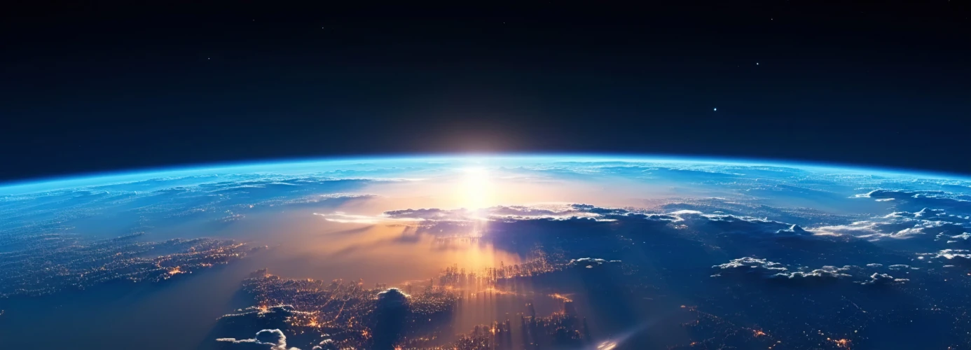 Earth's curvature from space with sunrise illuminating the atmosphere and a city below.