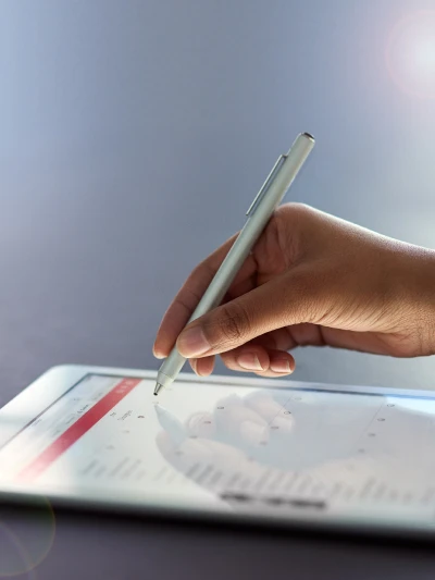 Hand using stylus on tablet screen