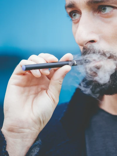 Person exhaling vapor from an e-cigarette