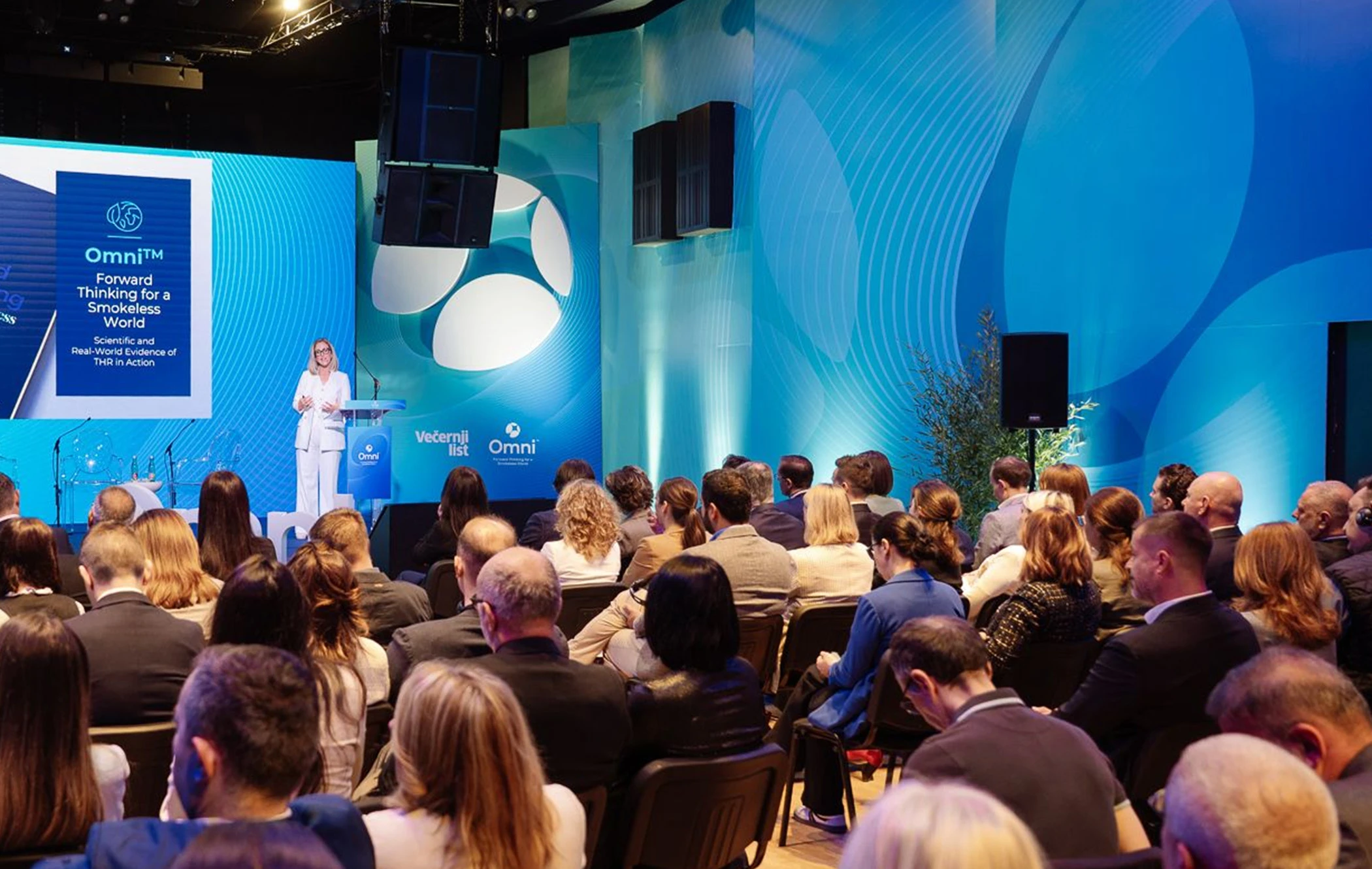 Corporate presentation with speakers on stage and large audience