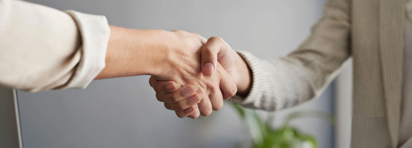 Close-up of handshake between two people in business attire