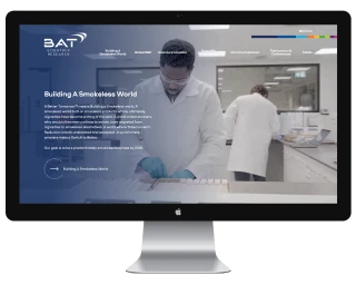 Computer monitor displaying BAT company website with scientists working in a laboratory.