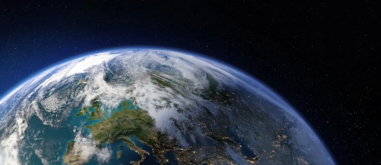 Wide-angle view of Earth from space, focusing on Europe and North Africa with cloud cover visible.